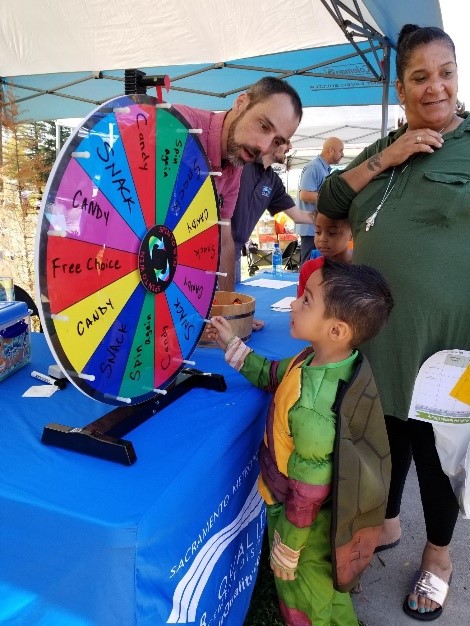 District staff helps kid spin prize wheel after his mom votes for 